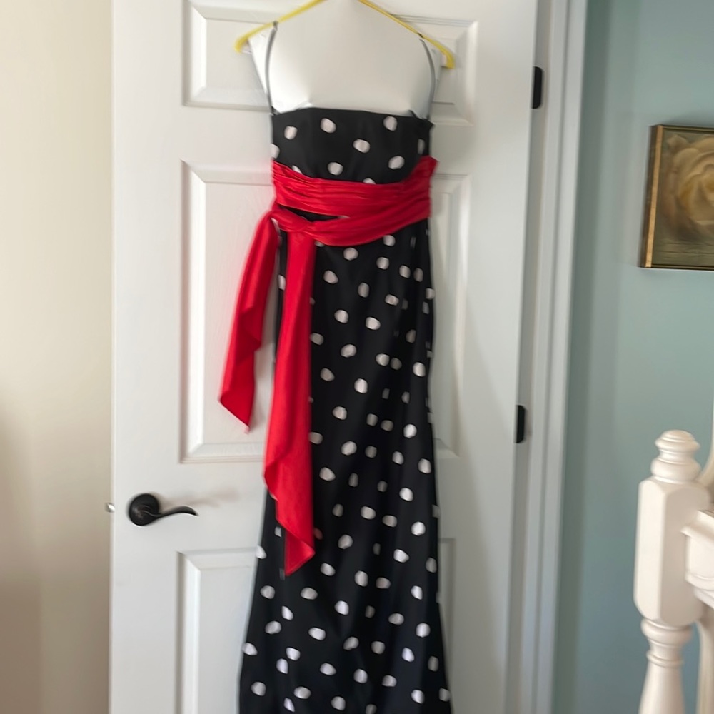 Stunning black and white polka dot prom or evening dress with a red sash